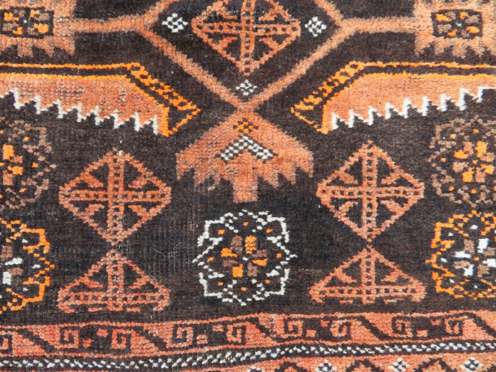 A hand-woven wool Afghan prayer rug featuring a dark brown central field with terracotta geometric motifs and a distinct pointed arch design. View VI