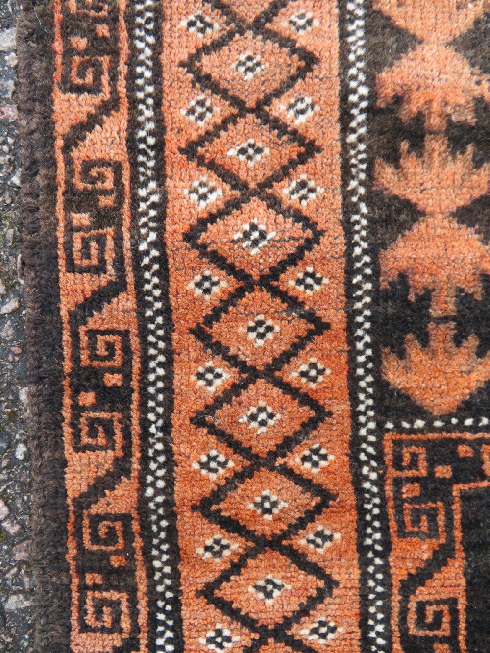 A hand-woven wool Afghan prayer rug featuring a dark brown central field with terracotta geometric motifs and a distinct pointed arch design. View VII