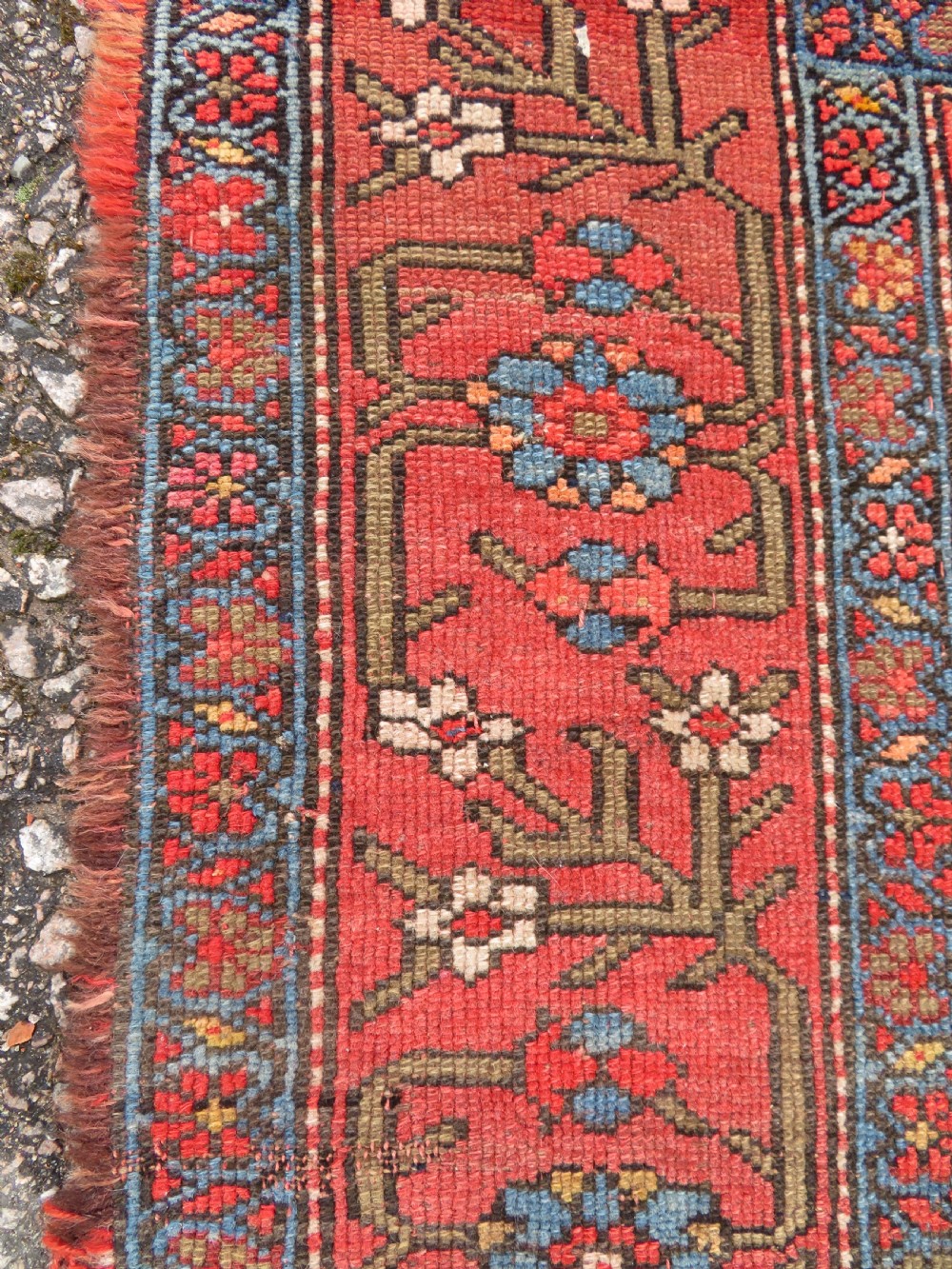 An antique hand-knotted Kurdish Bijar wool rug featuring a central red and blue medallion, cream patterned spandrels, and a terracotta floral border. View IX