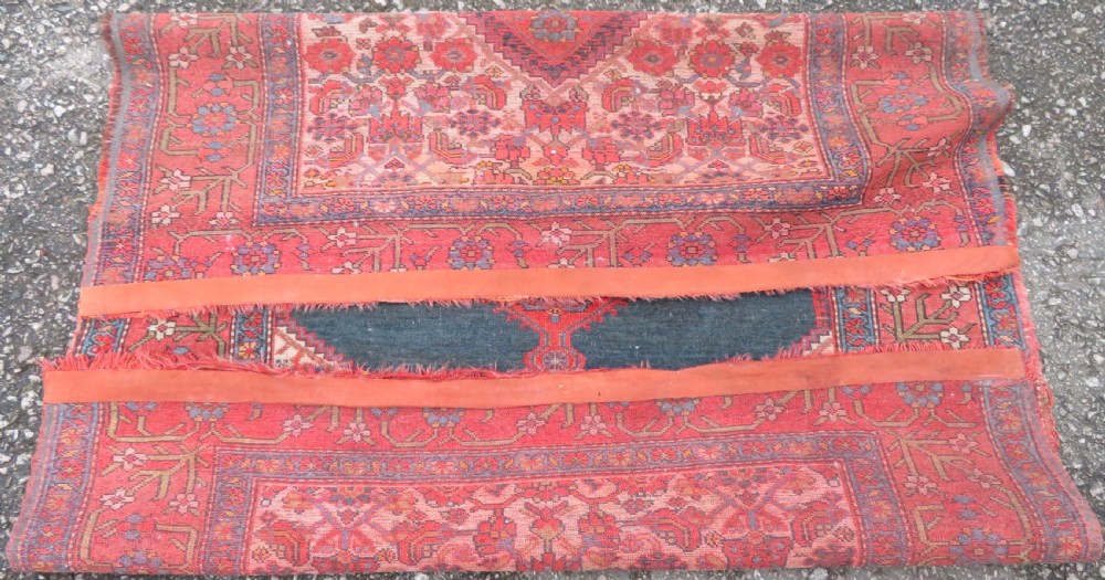 An antique hand-knotted Kurdish Bijar wool rug featuring a central red and blue medallion, cream patterned spandrels, and a terracotta floral border. View XI