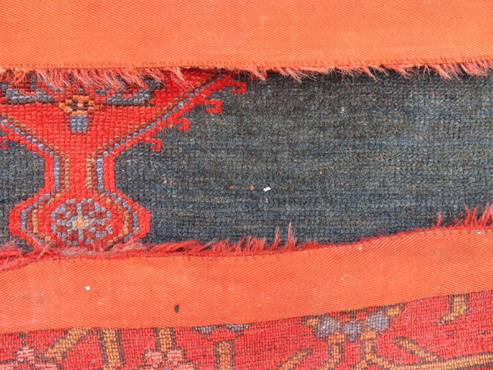 An antique hand-knotted Kurdish Bijar wool rug featuring a central red and blue medallion, cream patterned spandrels, and a terracotta floral border. View XIII