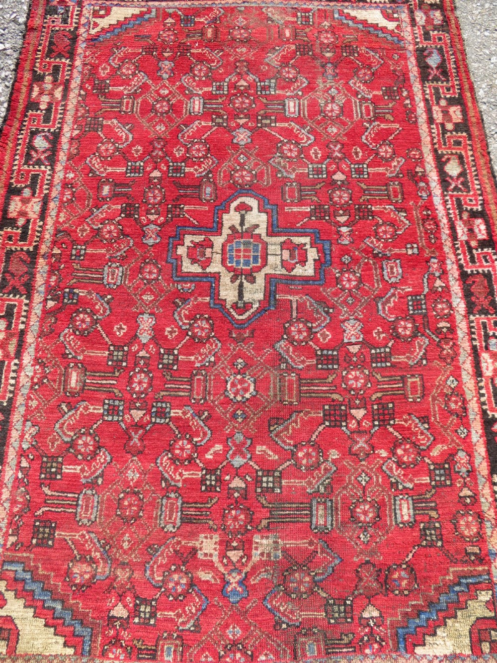 A rectangular distressed Persian Hamadan wool rug featuring a central stepped cross medallion on a crimson field with geometric borders. View II