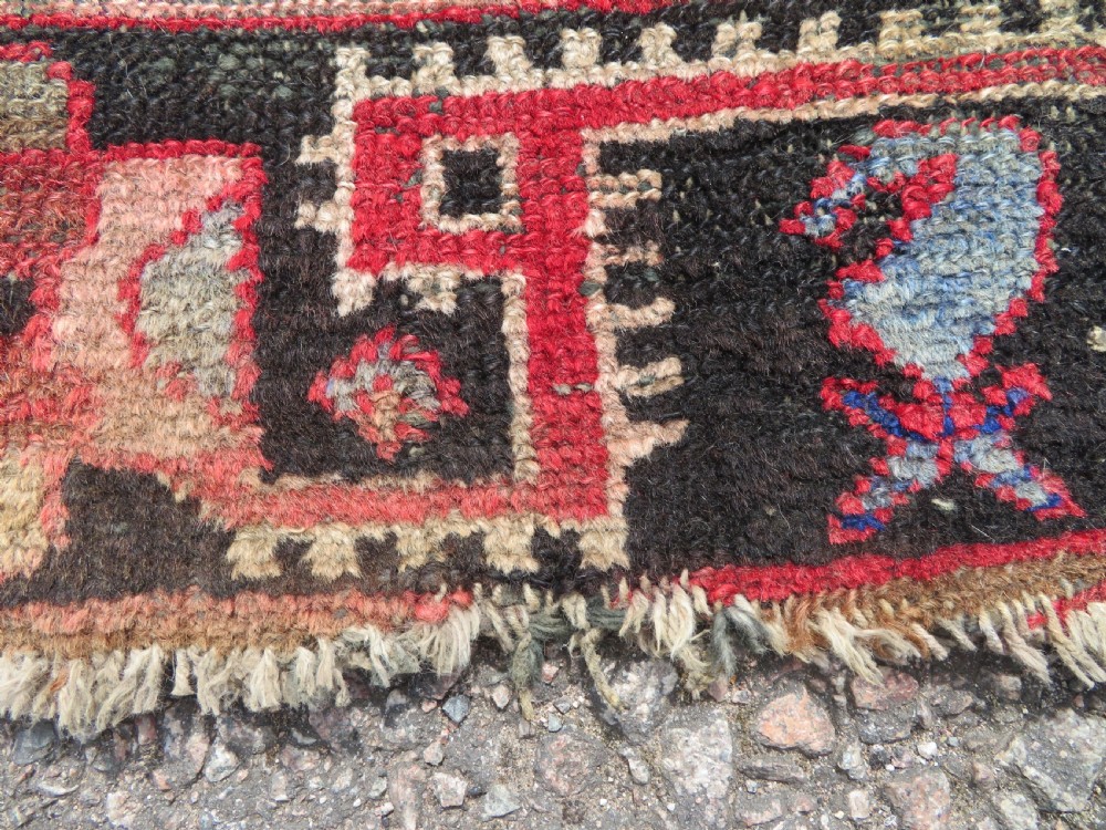 A rectangular distressed Persian Hamadan wool rug featuring a central stepped cross medallion on a crimson field with geometric borders. View VI