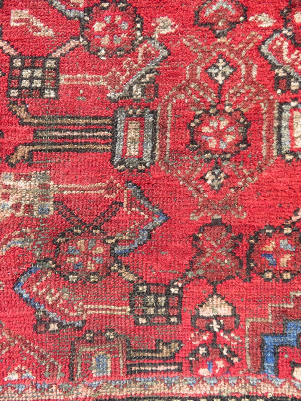 A rectangular distressed Persian Hamadan wool rug featuring a central stepped cross medallion on a crimson field with geometric borders. View VIII