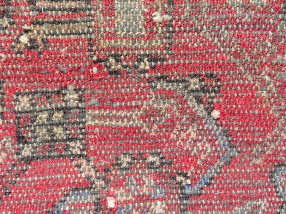 A rectangular distressed Persian Hamadan wool rug featuring a central stepped cross medallion on a crimson field with geometric borders. View XV