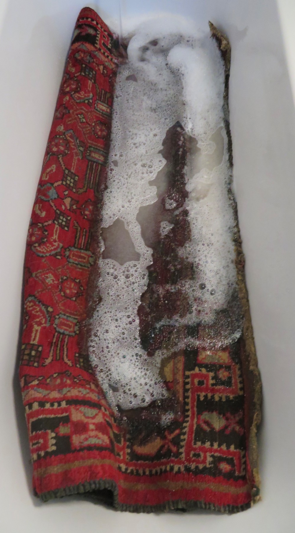 A rectangular distressed Persian Hamadan wool rug featuring a central stepped cross medallion on a crimson field with geometric borders. View XVIII