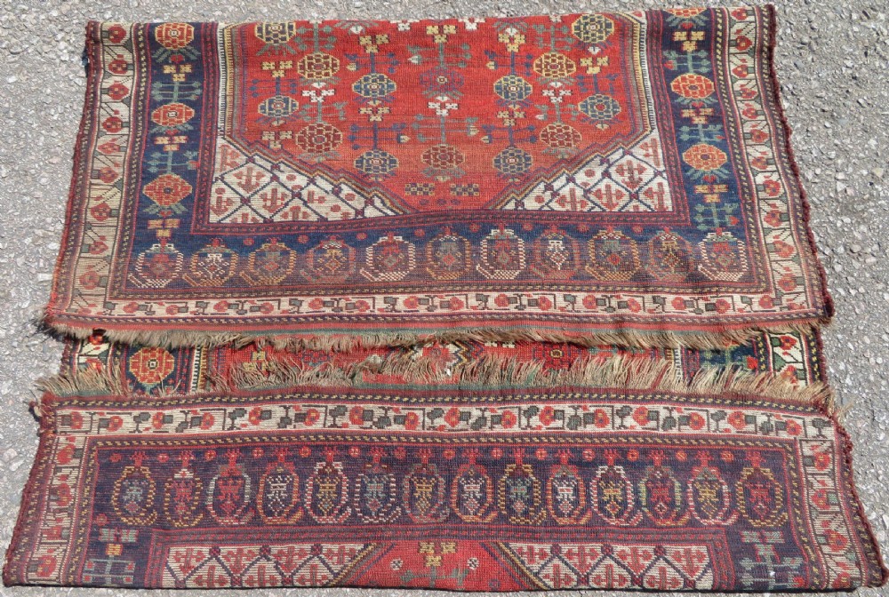An antique hand-knotted Khamseh wool rug featuring a red central field with a geometric medallion framed by navy blue and cream borders. View XV