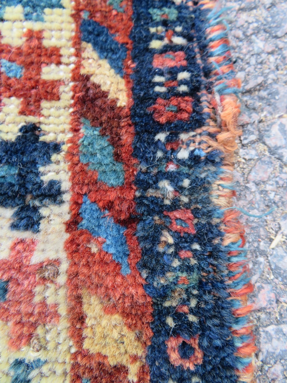 Distressed hand-knotted South Persian Khamseh tribal rug featuring nested diamond medallions, stylized animal motifs, and a multi-banded geometric border in navy blue, terracotta, and cream. View XIII