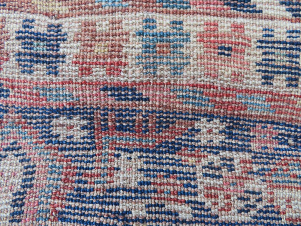 Distressed hand-knotted South Persian Khamseh tribal rug featuring nested diamond medallions, stylized animal motifs, and a multi-banded geometric border in navy blue, terracotta, and cream. View XVII