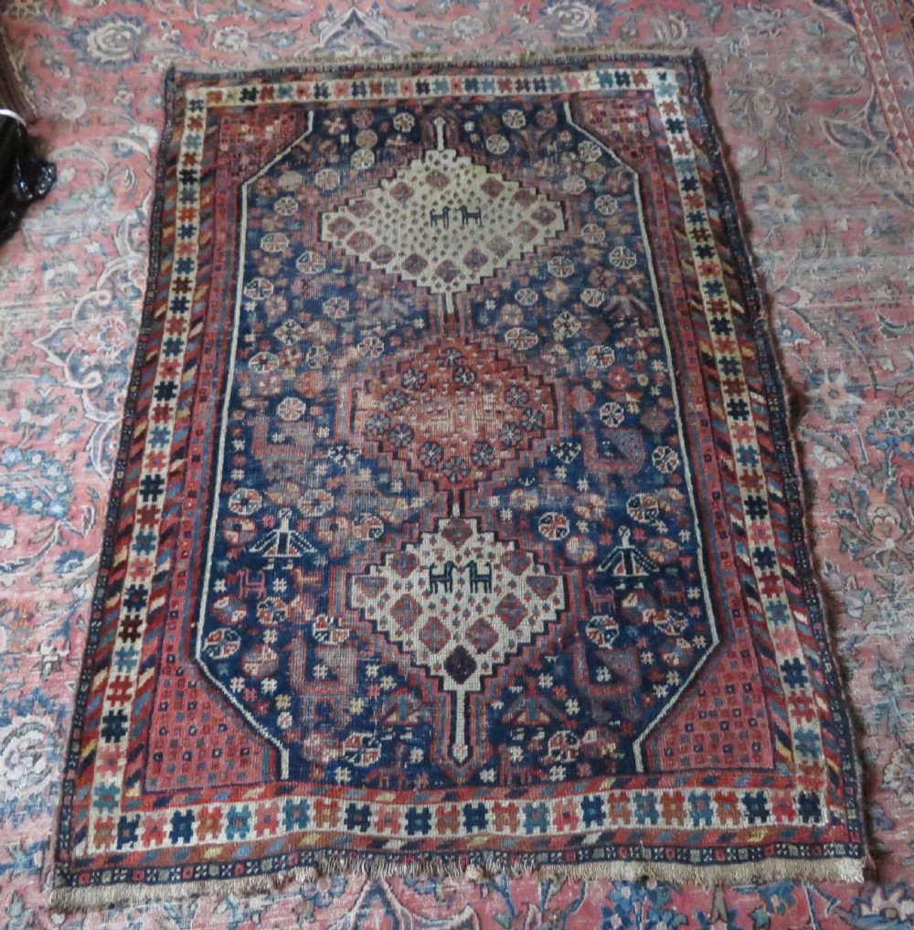 Distressed hand-knotted South Persian Khamseh tribal rug featuring nested diamond medallions, stylized animal motifs, and a multi-banded geometric border in navy blue, terracotta, and cream. View XVIII
