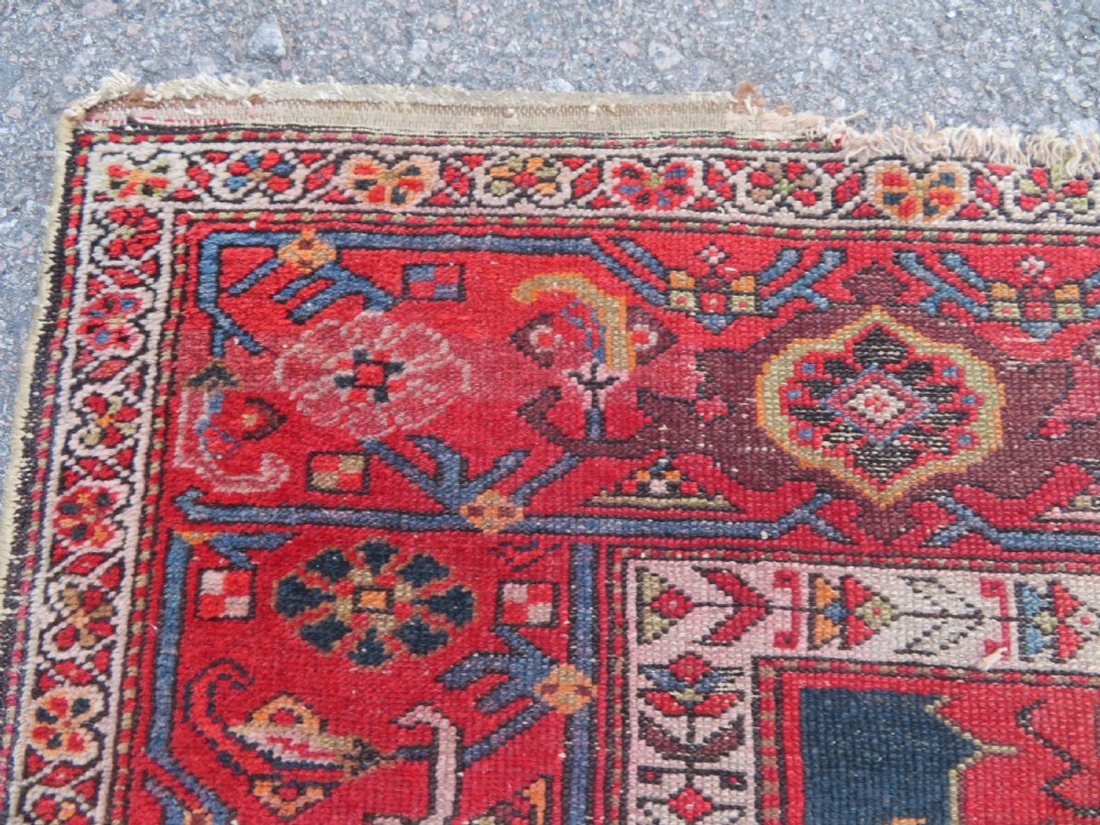 An antique hand-knotted North West Persian long rug featuring five geometric central medallions set against a dark field with a red pattern border. View VIII
