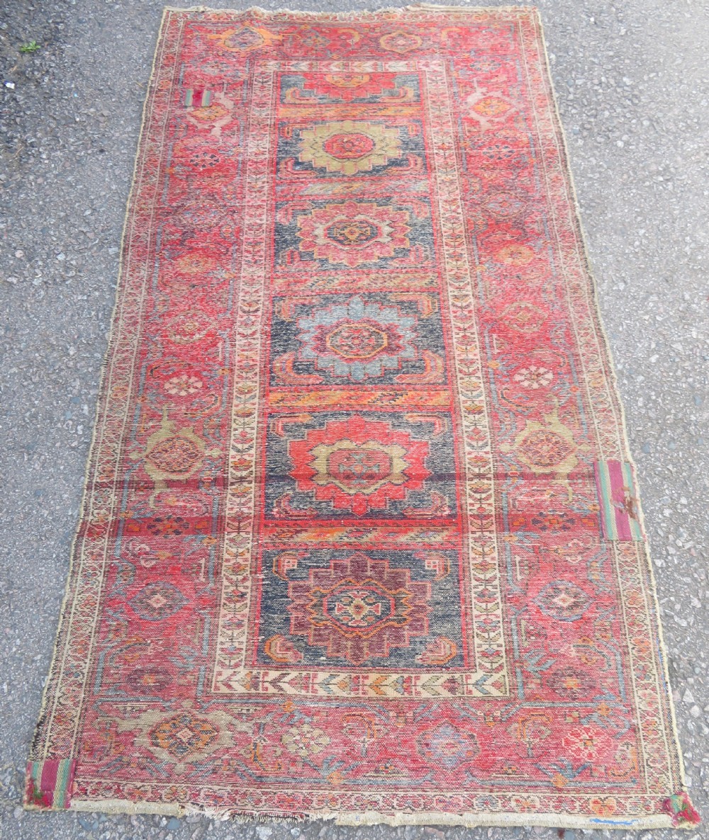 An antique hand-knotted North West Persian long rug featuring five geometric central medallions set against a dark field with a red pattern border. View XIV