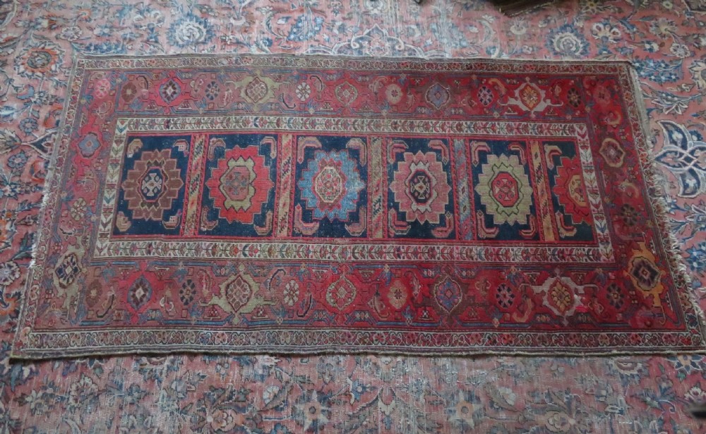 An antique hand-knotted North West Persian long rug featuring five geometric central medallions set against a dark field with a red pattern border. View XXI