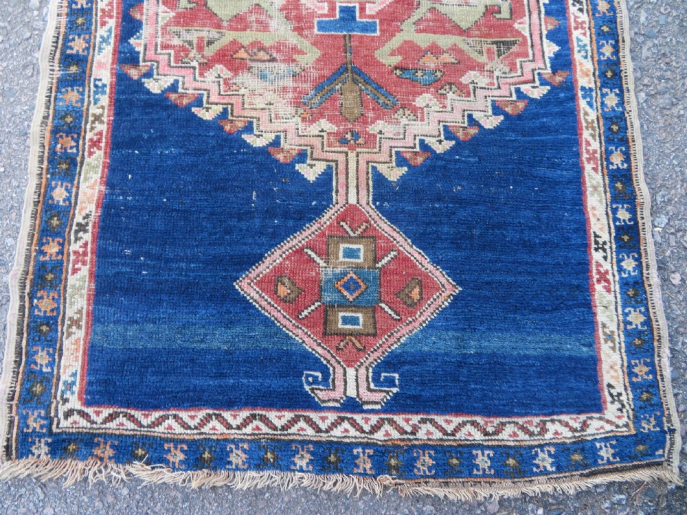 An antique hand-woven Turkish runner rug featuring indigo blue ends and a distressed red and cream geometric central medallion pattern. View II