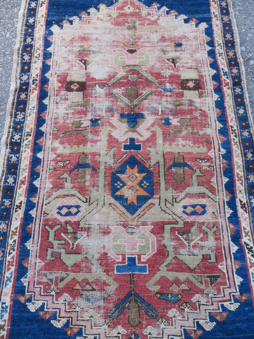 An antique hand-woven Turkish runner rug featuring indigo blue ends and a distressed red and cream geometric central medallion pattern. View III