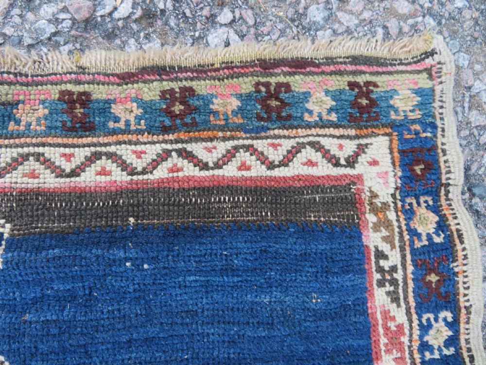 An antique hand-woven Turkish runner rug featuring indigo blue ends and a distressed red and cream geometric central medallion pattern. View VI