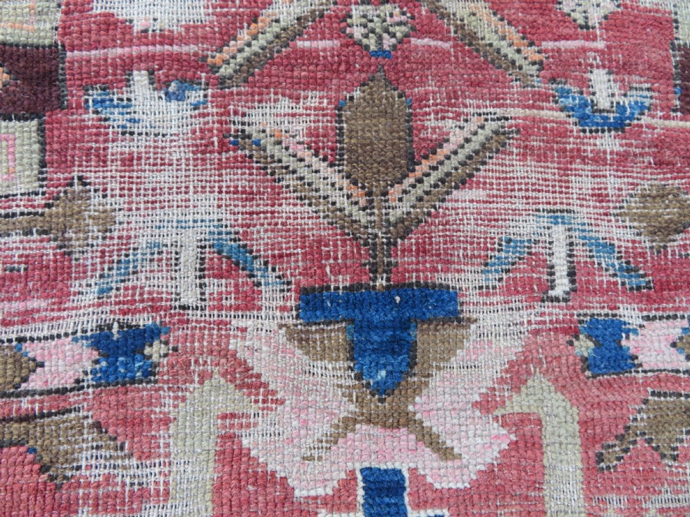 An antique hand-woven Turkish runner rug featuring indigo blue ends and a distressed red and cream geometric central medallion pattern. View IX