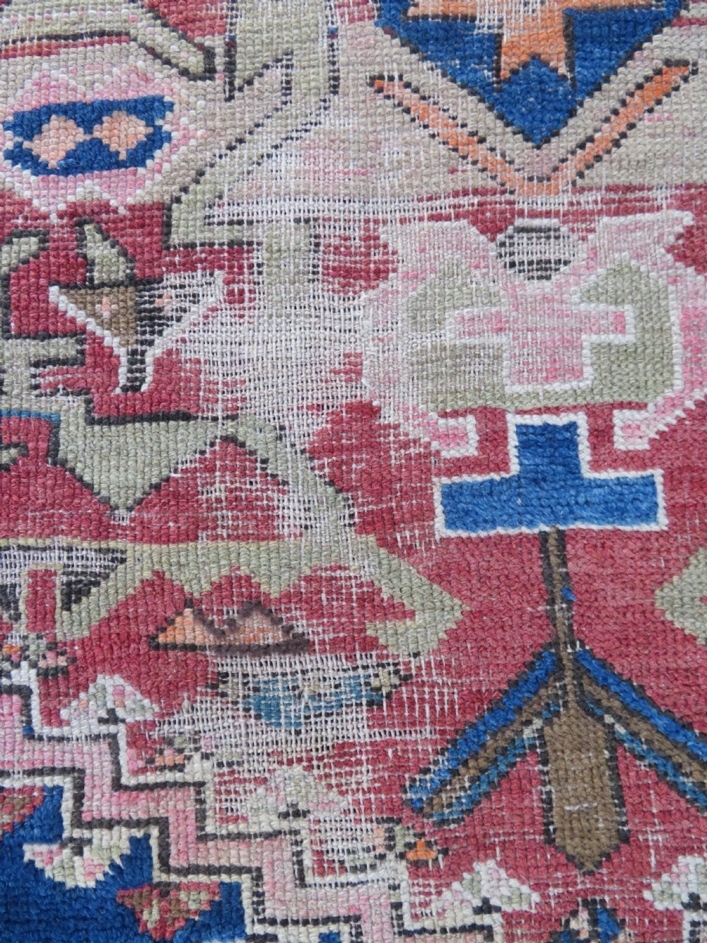 An antique hand-woven Turkish runner rug featuring indigo blue ends and a distressed red and cream geometric central medallion pattern. View X