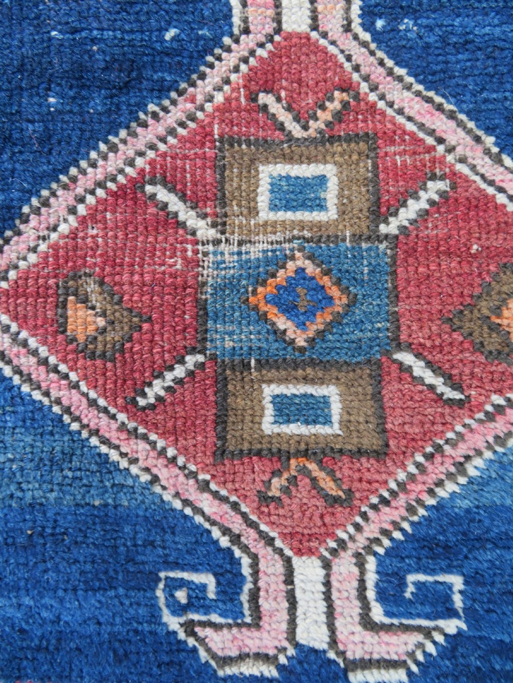 An antique hand-woven Turkish runner rug featuring indigo blue ends and a distressed red and cream geometric central medallion pattern. View XI