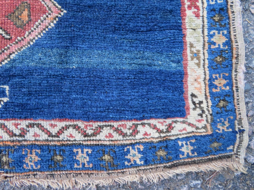 An antique hand-woven Turkish runner rug featuring indigo blue ends and a distressed red and cream geometric central medallion pattern. View XIII