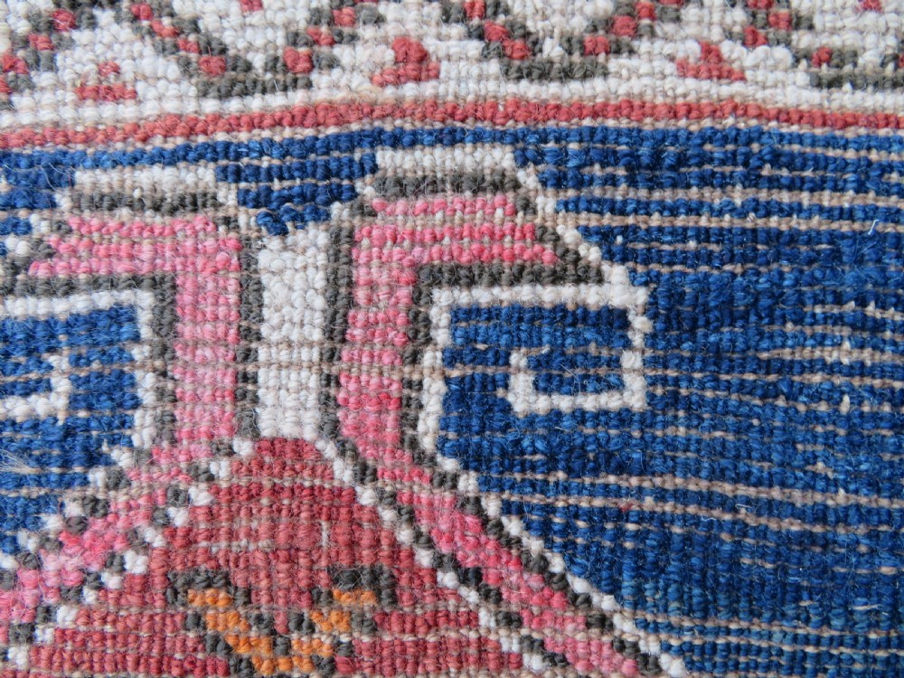 An antique hand-woven Turkish runner rug featuring indigo blue ends and a distressed red and cream geometric central medallion pattern. View XIX