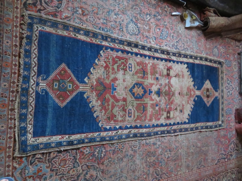 An antique hand-woven Turkish runner rug featuring indigo blue ends and a distressed red and cream geometric central medallion pattern. View XX