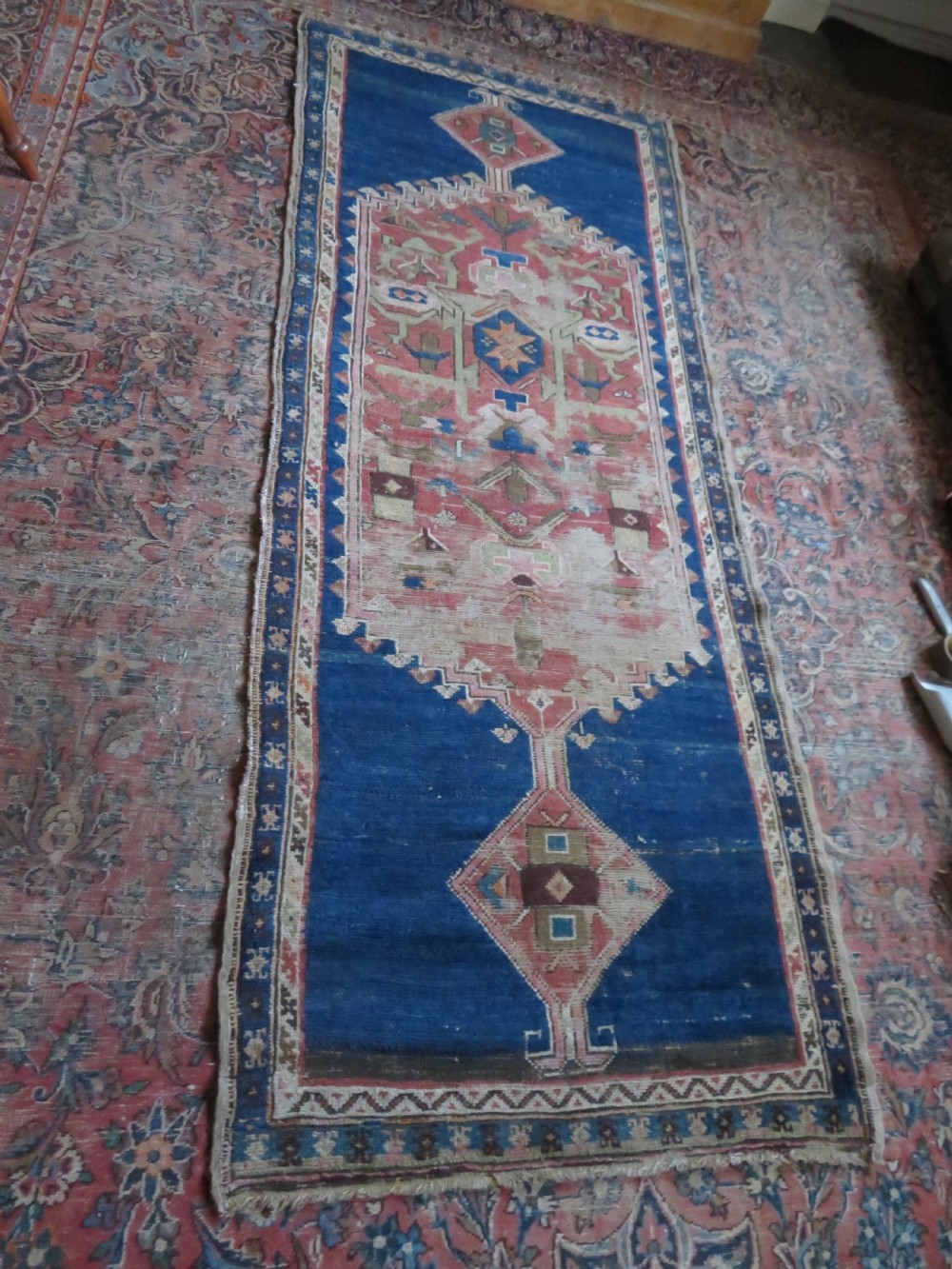 An antique hand-woven Turkish runner rug featuring indigo blue ends and a distressed red and cream geometric central medallion pattern. View XXI