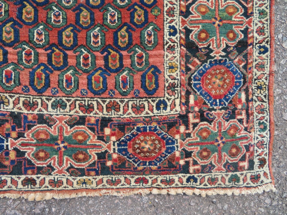 A hand-knotted Bakhtiari tribal wool rug with central ivory and blue medallions framed by a dark navy field with repeating boteh patterns and a detailed geometric border. View IX