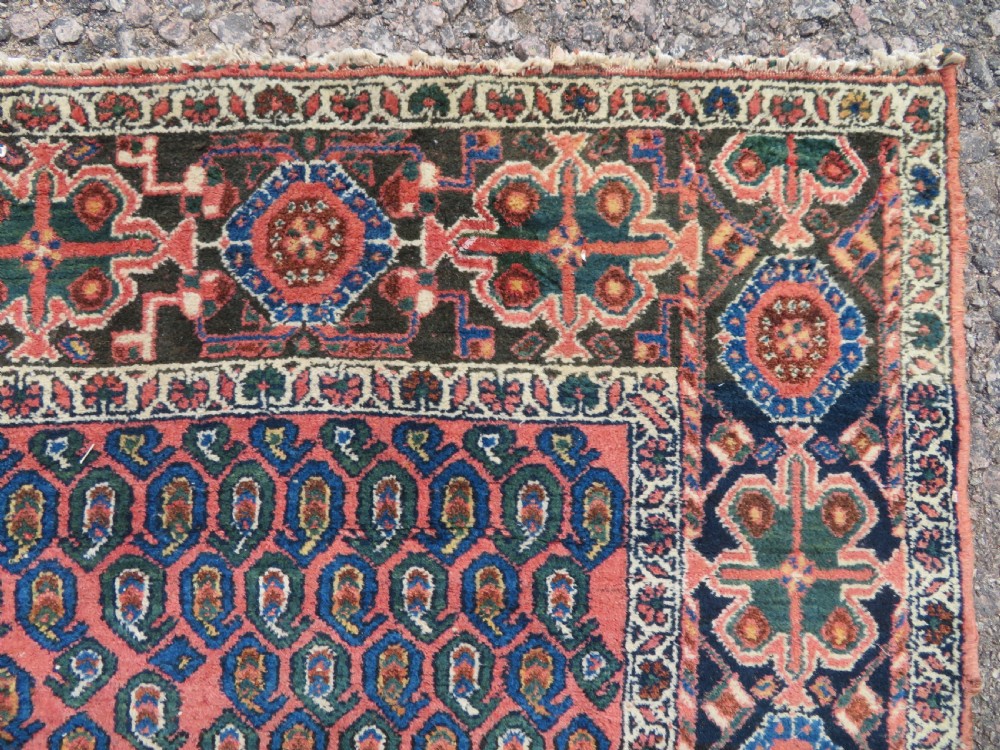 A hand-knotted Bakhtiari tribal wool rug with central ivory and blue medallions framed by a dark navy field with repeating boteh patterns and a detailed geometric border. View XI