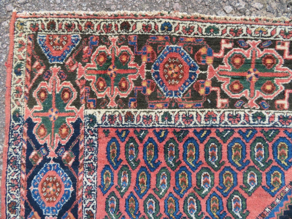 A hand-knotted Bakhtiari tribal wool rug with central ivory and blue medallions framed by a dark navy field with repeating boteh patterns and a detailed geometric border. View XIII
