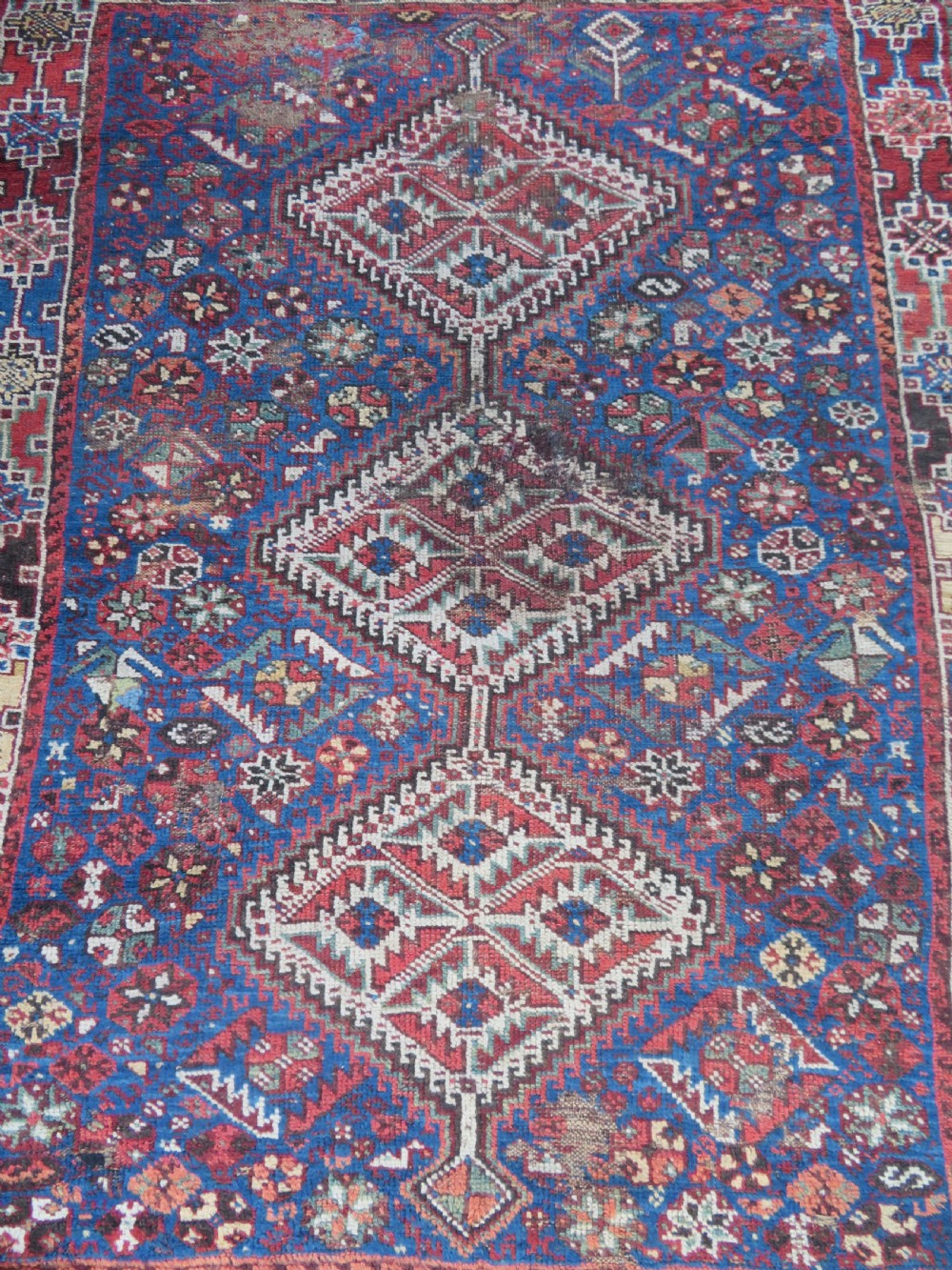 An antique Khamseh hand-knotted wool rug featuring three stacked geometric diamond medallions on an indigo blue field surrounded by intricate patterned borders. View II