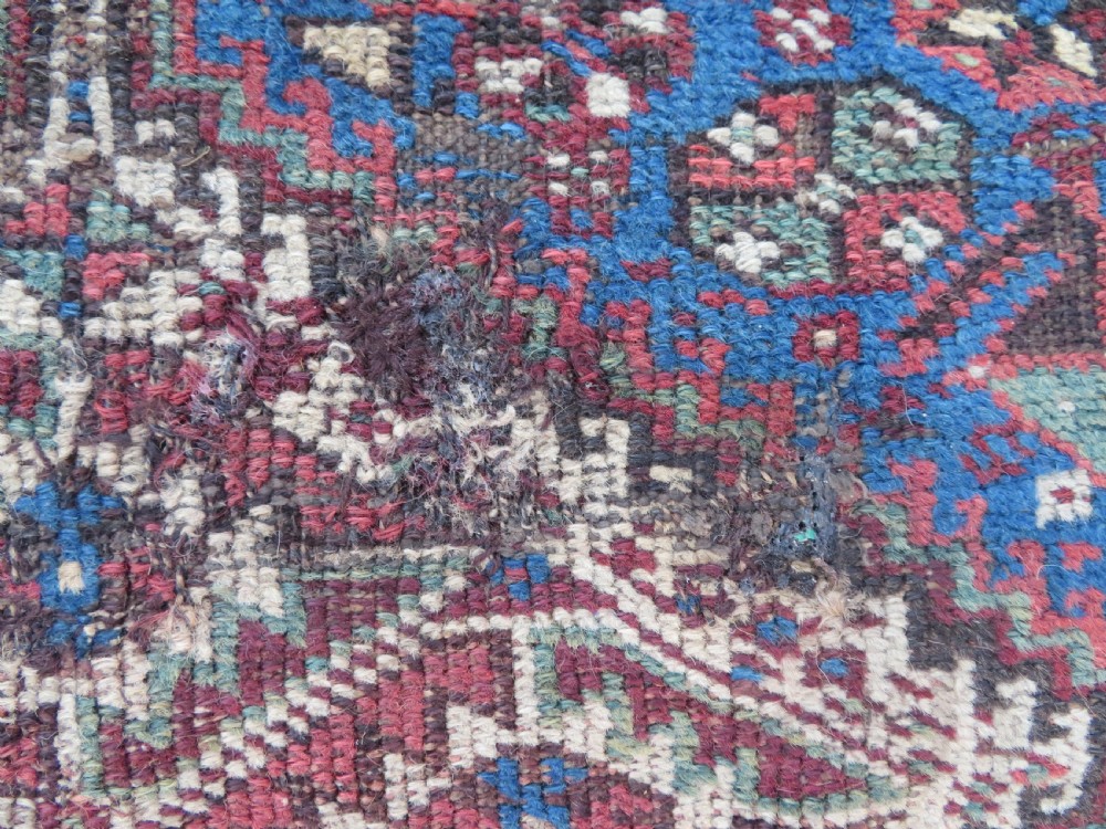 An antique Khamseh hand-knotted wool rug featuring three stacked geometric diamond medallions on an indigo blue field surrounded by intricate patterned borders. View III