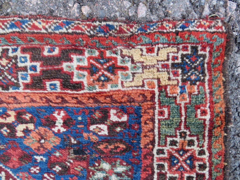 An antique Khamseh hand-knotted wool rug featuring three stacked geometric diamond medallions on an indigo blue field surrounded by intricate patterned borders. View VI
