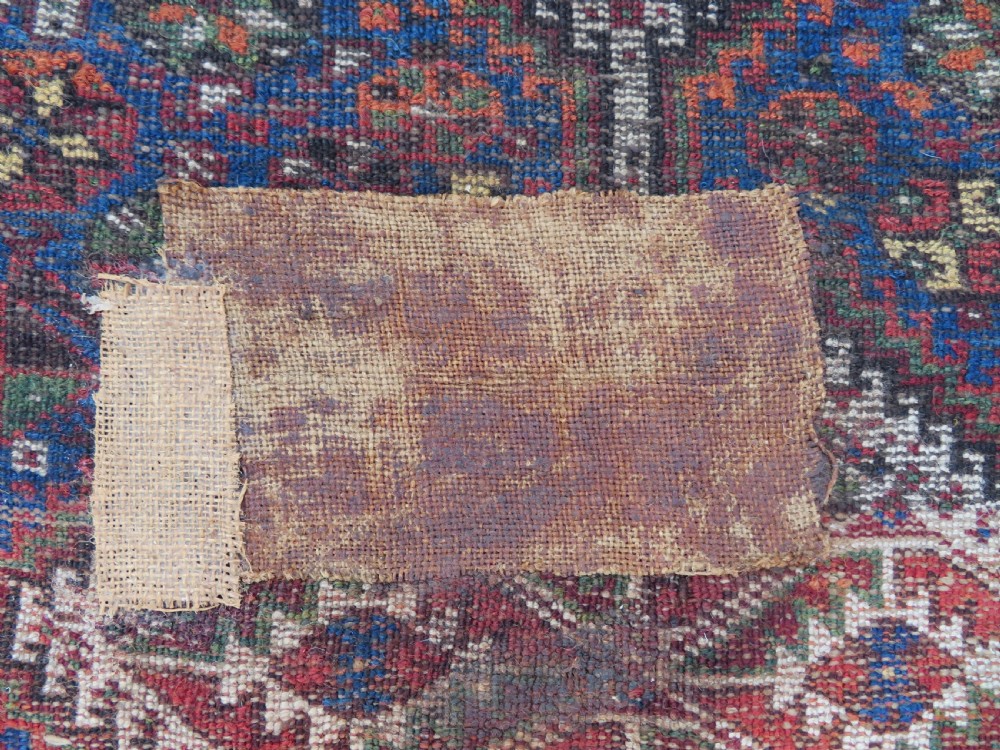 An antique Khamseh hand-knotted wool rug featuring three stacked geometric diamond medallions on an indigo blue field surrounded by intricate patterned borders. View XIV