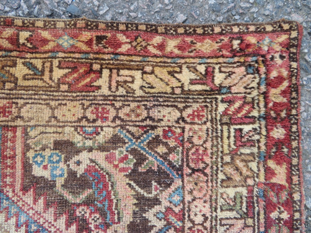 An antique hand-knotted Sarab rug with a geometric central medallion, camel hair field, and distressed terracotta borders. View VII