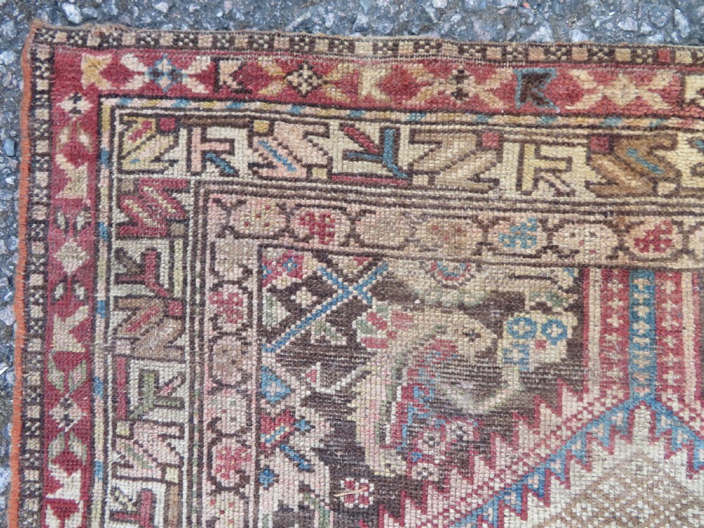 An antique hand-knotted Sarab rug with a geometric central medallion, camel hair field, and distressed terracotta borders. View VIII