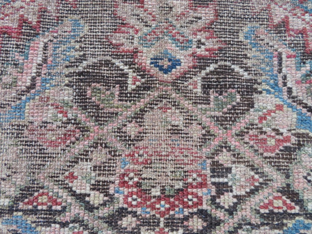 An antique hand-knotted Sarab rug with a geometric central medallion, camel hair field, and distressed terracotta borders. View IX