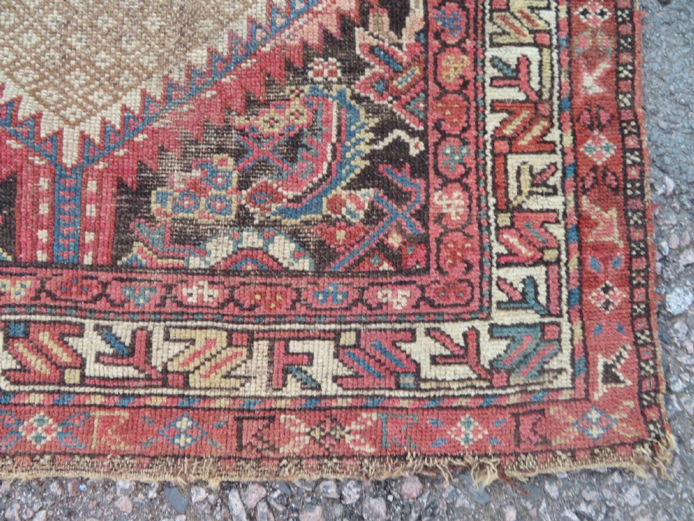 An antique hand-knotted Sarab rug with a geometric central medallion, camel hair field, and distressed terracotta borders. View X