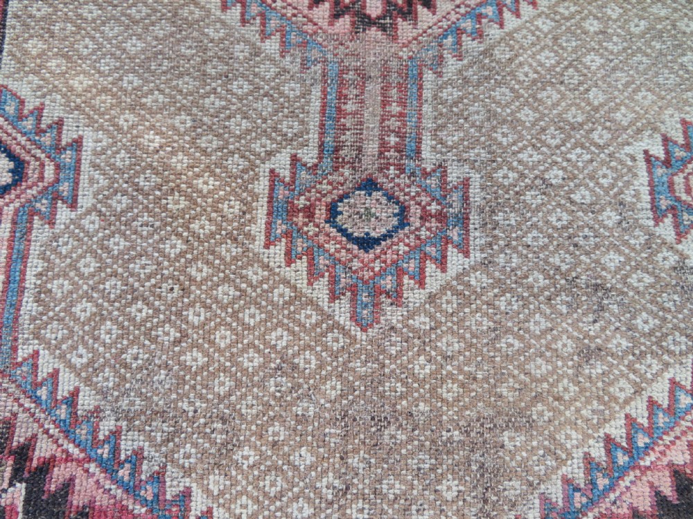 An antique hand-knotted Sarab rug with a geometric central medallion, camel hair field, and distressed terracotta borders. View XII