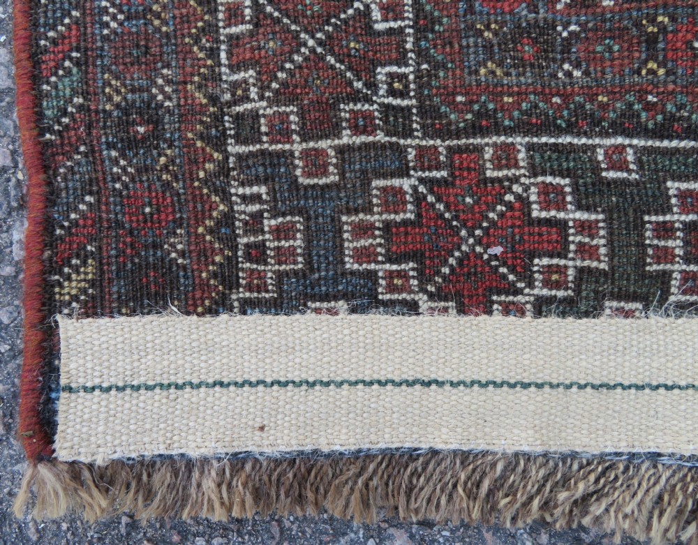 A rectangular hand-knotted antique Khamseh wool rug featuring geometric diamond medallions and intricate border patterns in terracotta, dark brown, and cream. View XX