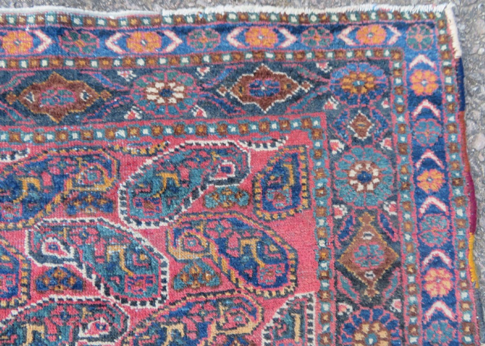 An antique hand-knotted wool Afshar tribal rug featuring a repeating boteh pattern on a terracotta field with geometric blue and cream borders. View VI