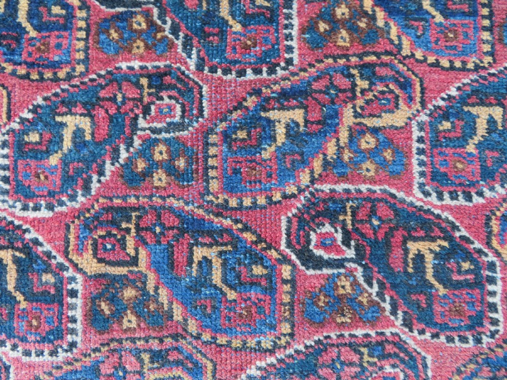 An antique hand-knotted wool Afshar tribal rug featuring a repeating boteh pattern on a terracotta field with geometric blue and cream borders. View IX
