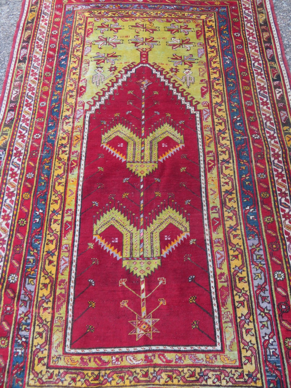 An antique hand-knotted Turkish Kirsehir prayer rug featuring a central red mihrab arch framed by a yellow spandrel and multi-tiered geometric borders. View II