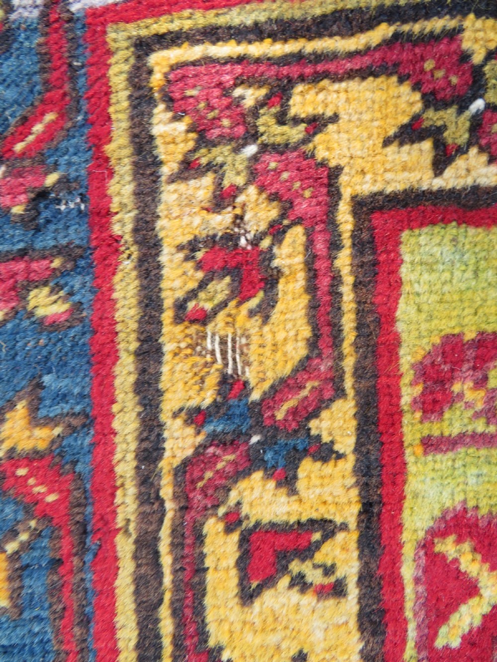 An antique hand-knotted Turkish Kirsehir prayer rug featuring a central red mihrab arch framed by a yellow spandrel and multi-tiered geometric borders. View VI