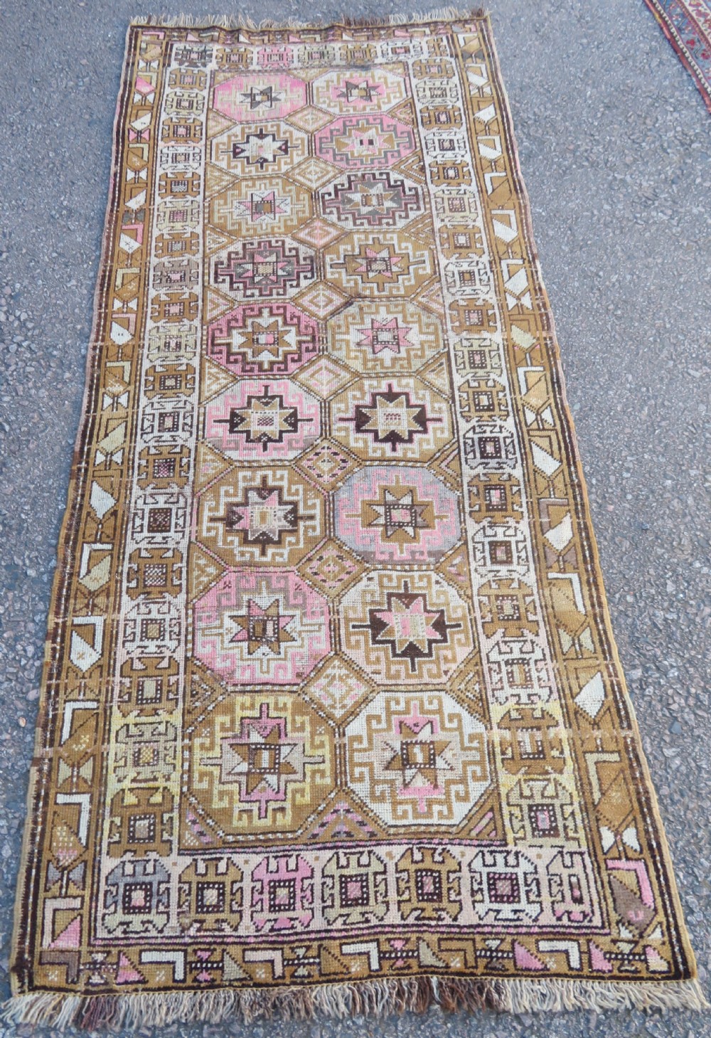 An antique Kurdish hand-knotted wool rug runner featuring repeated geometric octagonal medallions in shades of pink, tan, cream, and dark brown. View II