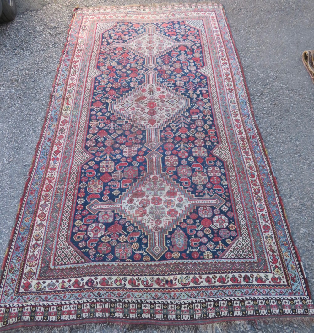 An antique hand-knotted Persian Khamseh carpet featuring three central diamond pole medallions on a dark navy blue field filled with geometric tribal bird and flower motifs surrounded by intricate decorative borders. View II