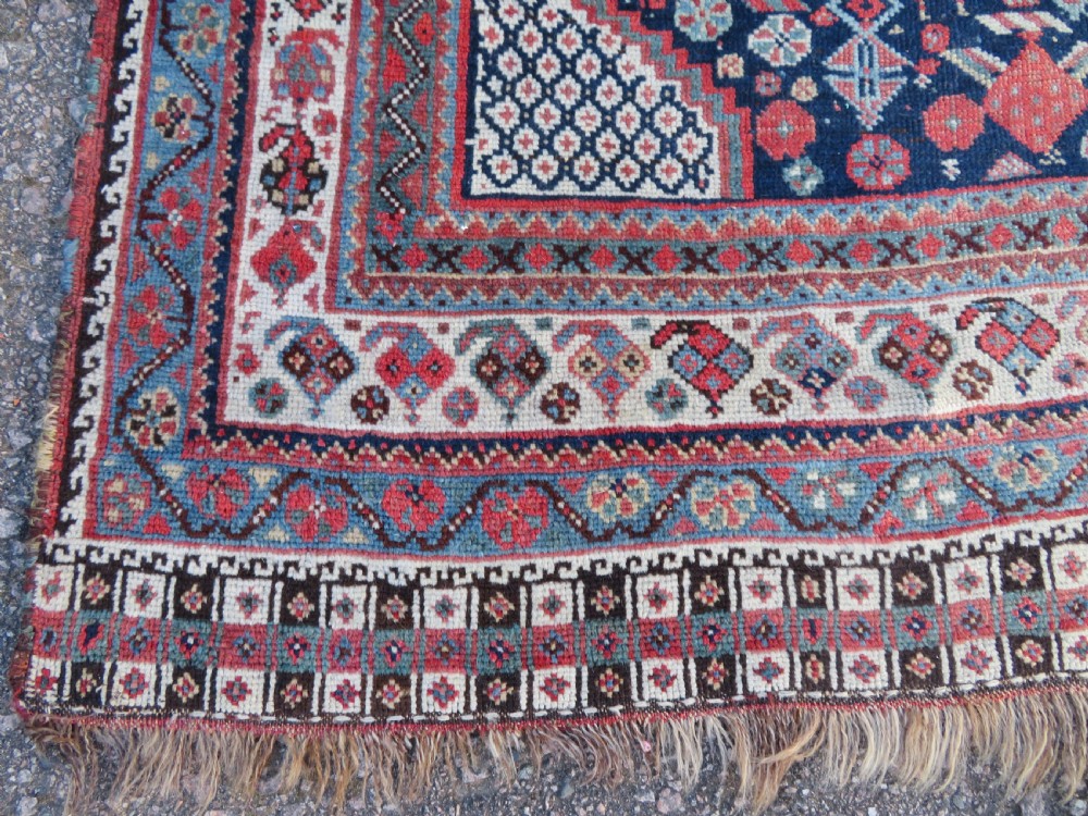 An antique hand-knotted Persian Khamseh carpet featuring three central diamond pole medallions on a dark navy blue field filled with geometric tribal bird and flower motifs surrounded by intricate decorative borders. View XII