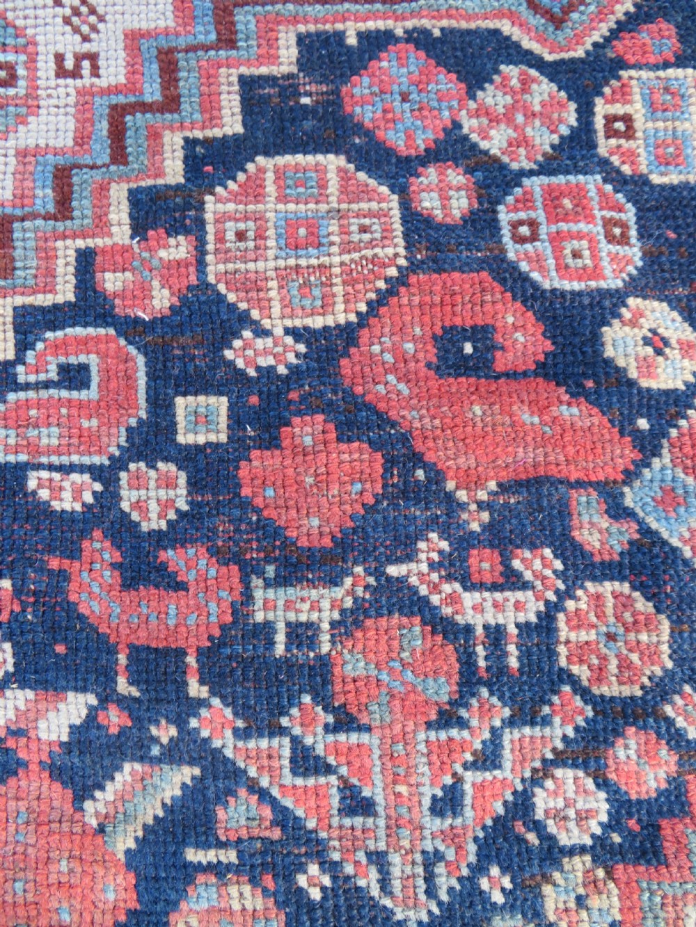 An antique hand-knotted Persian Khamseh carpet featuring three central diamond pole medallions on a dark navy blue field filled with geometric tribal bird and flower motifs surrounded by intricate decorative borders. View XIV