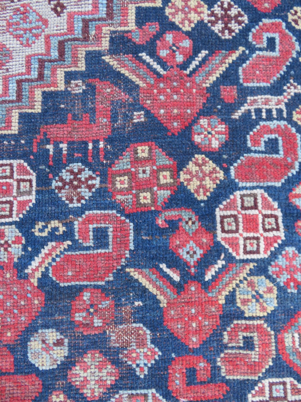 An antique hand-knotted Persian Khamseh carpet featuring three central diamond pole medallions on a dark navy blue field filled with geometric tribal bird and flower motifs surrounded by intricate decorative borders. View XVI