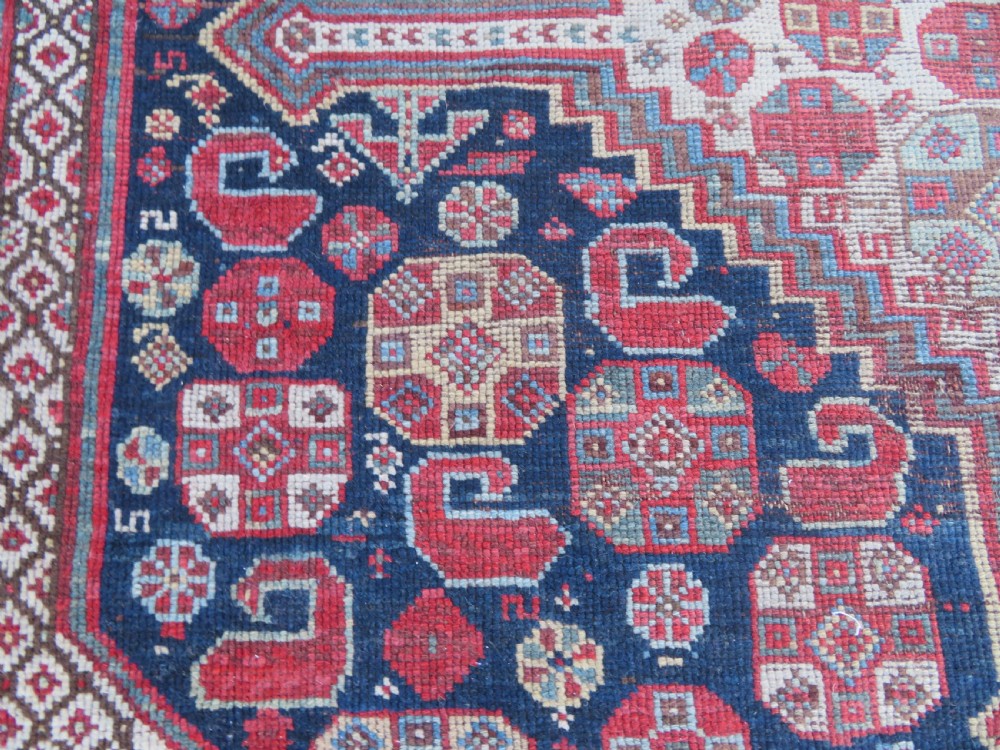An antique hand-knotted Persian Khamseh carpet featuring three central diamond pole medallions on a dark navy blue field filled with geometric tribal bird and flower motifs surrounded by intricate decorative borders. View XIX